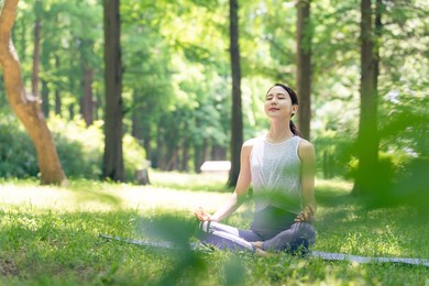asian woman meditating in the woods. forest yoga. mindfulness.