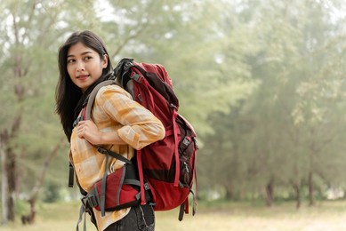 asian beautiful female backpacker tourists in the forest looking sideways.