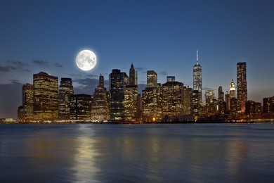 panoramic view new york city manhattan downtown skyline at night with skyscrapers and bright full moon