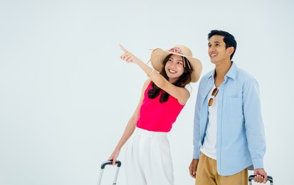 exciting travel, happy holiday. summer vacation. asian couple travelers looking out with exciting, man and young woman pointing with suitcases on trip with copy space, isolated on white background.