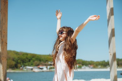 little girl jumping on the beach on the shore of the city beach in the summer holidays