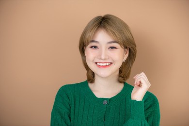 photo portrait smiling woman wearing green sweater isolated beige color background