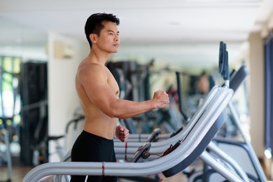 man exercising in gym. asian bodybuilder lifting weights. sport and healthy activity for young male. active chinese athlete in training. body building exercise work out.