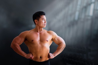 man exercising in gym. asian bodybuilder lifting weights. sport and healthy activity for young male. active chinese athlete in training. body building exercise work out.