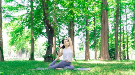 asian woman doing yoga in green forest. park yoga. mindfulness.