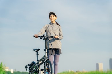 asian woman with mini velo bicycle. cycling in nature.