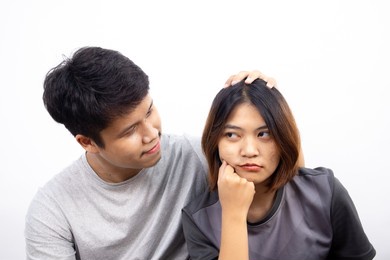 asian men are make friendly again their disgruntled girlfriend by apologizing and reconciling on white background