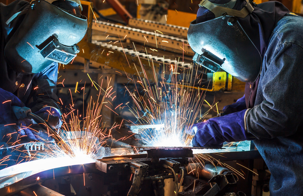 worker with protective mask welding metal