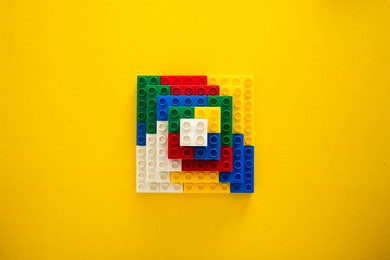 plastic building blocks on yellow background