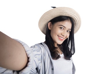 asian woman with a hat taking a self-portrait isolated over white background