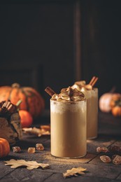 autumn pumpkin spice latte with whipped cream and cinnamon on dark background