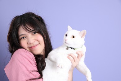 the cute young asian girl with casual clothes standing on the purple background.