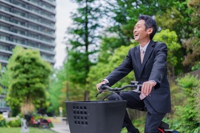 elderly businessman bicycling to work