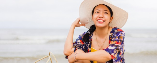 asian traveller woman sit back and relax on the beach by the sea background on weekend vacation.concept of happy solo travel.
