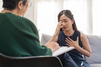 psychology, depression. sad asian young woman cry about break up or divorce, consulting with psychologist ,psychiatrist while patient counseling mental with doctor at clinic. encouraging, therapy.