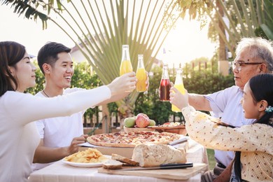 happy asian family enjoying dinner party in the garden. outdoor dinner party on holiday.