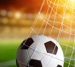 soccer ball in goal on stadium background.