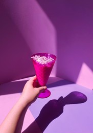 dessert of ice cream in a purple vase with lilac flowers. in the hands of a woman, a cream bowl with ice cream. 