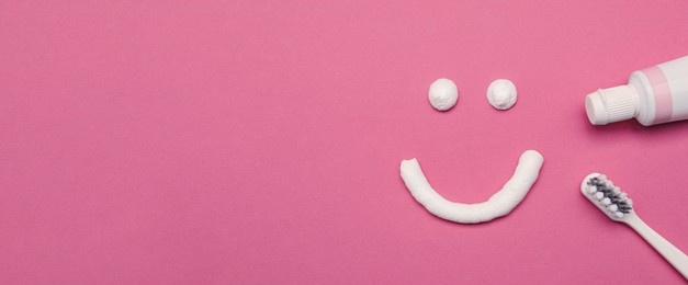 smiling face made of toothpaste, brush and tube on pink background, flat lay with space for text. banner design