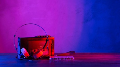 vintage cassette tape player in neon light. 90s advertisement style. disco party nostalgy concept