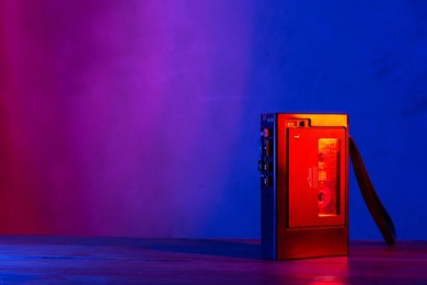 vintage cassette tape player in neon light. 90s advertisement style. disco party nostalgy concept