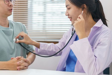 healthcare concept, female doctor using stethoscope with patient to examining lung and heart rate.