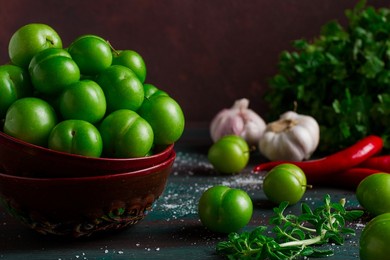 tkemali, green cherry plum, with ingredients for sauce,  on a wooden table, close-up, rustic, food background, no people, selective focus,
