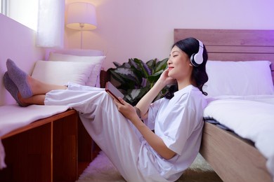 smiling teenage girl enjoying listening to good music when relaxing at home