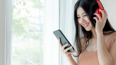 lifestyle beautiful asian woman cute girl  feel happy enjoy listening to music with earphones headphones on white bedroom