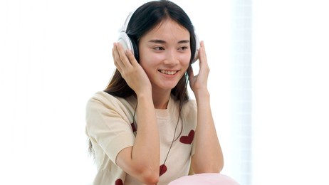 happy asian woman modern wireless headphones listening to music