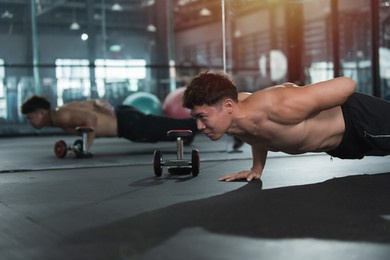 man exercising in gym. male excercise ingym. man planking on floor in gym. 