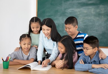 asian female teacher teaching her students in classroom, education concept