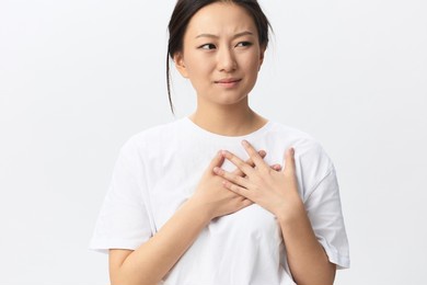 heart attack. suffering from pain tanned beautiful young asian woman hold hand on chest heart crying posing isolated on white background. injuries poor health illness concept. cool offer banner