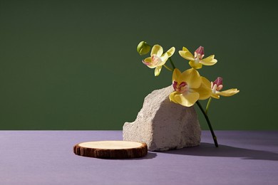 front view of rock decorated with green leaf and flower in green background nature 