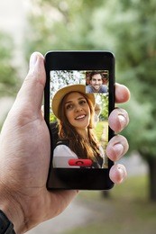 close up of a male hand holding a smart phone during a video call with his girlfriend