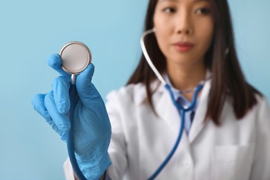 asian doctor with stethoscope on blue background