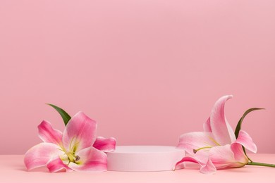 podium with pink lily, round cylinder scene with flowers on pink background, display for cosmetics, perfume and product presentation