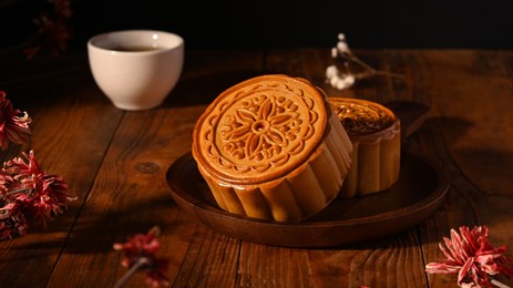 delicious traditional chinese moon cakes and tea on wooden background. mid autumn festival or chinese traditional festival