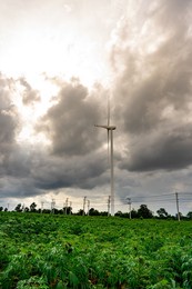 wind turbine sitting on green land and blue sky and white clouds background