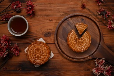 top view, traditional chinese mooncakes, tea and dried flower on rustic wooden background