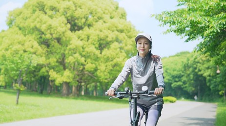 young asian woman riding bicycle in the park.