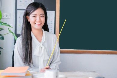 portrait attractive of smiling asian teacher woman teaching student in online classroom, female teacher present empty on blackboard, high school and back to school concept.