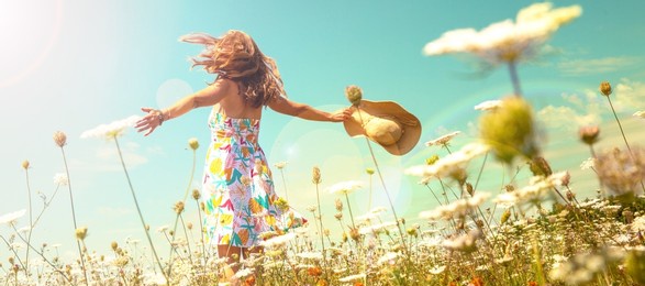 woman in a field with flowers- freedom,  active,  happiness concept