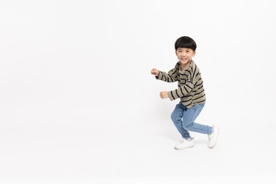 happy asian little boy dancing isolated on white background, full length and five years old