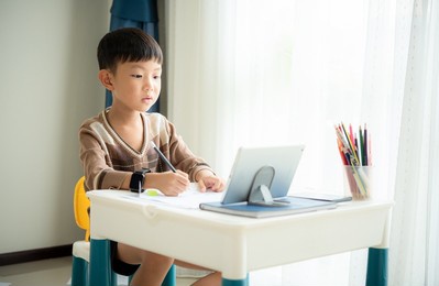 kid using tablet and smartphone learning online at home,child practice drawing from a tablet, learning online education, asian boy doing homework.