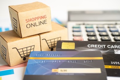 shopping online box with credit card and calculator on graph. finance commerce import export business concept.