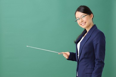 young woman with glasses pointing copy space against blackboard