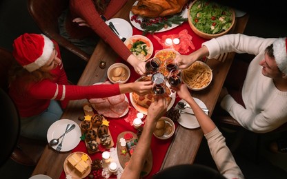 overhead view on family sitting around christmas table with traditional christmas roast