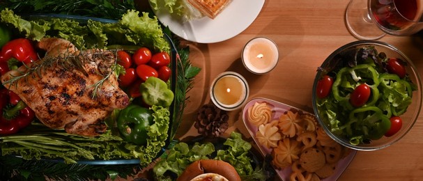 above view of homemade roasted turkey, glass of red wine and all sides dishes on thanksgiving table or christmas dinner