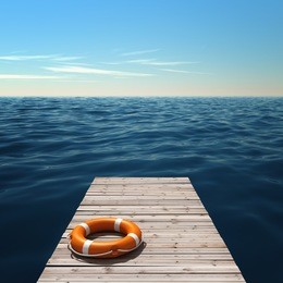 wooden pier near the sea with lifebuoy